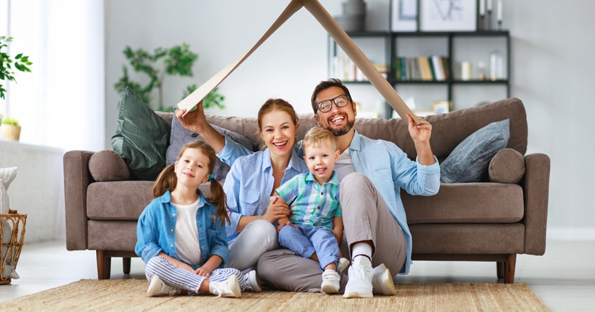 Young family woman, man and two children smiling in the sun